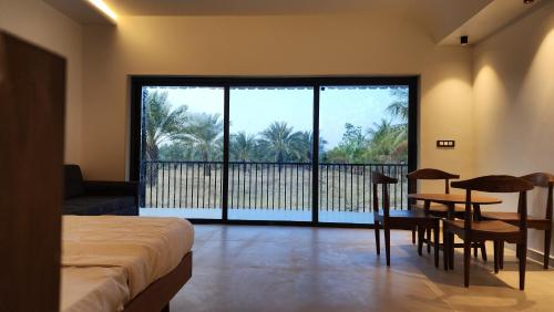 una camera con letto e tavolo e un balcone di Amrutiya Farmview Suit a Bhuj