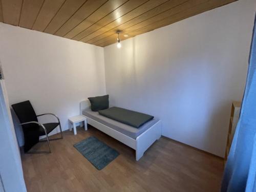Habitación pequeña con cama y silla en Ferienunterkunft&Monteure C.C, en Schwabach
