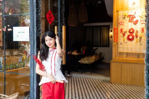 a young girl standing in front of a store at Seaforest Hotel by Haviland in Da Nang