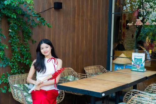 a girl sitting at a table in front of a table at Seaforest Hotel by Haviland in Da Nang