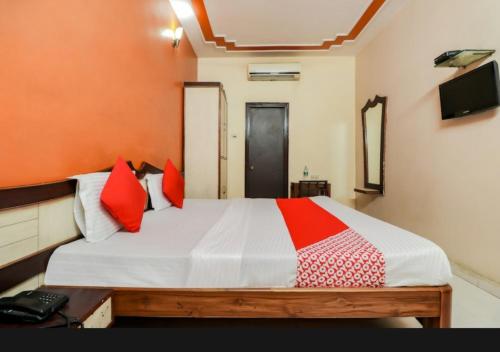 a bedroom with a large bed with red pillows at Hotel sunrise in Lucknow