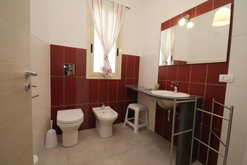 a bathroom with a toilet and a sink at Villa Venera Fontane Bianche Charme Apartments in Fontane Bianche