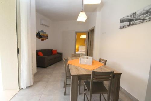 a dining room with a table and chairs and a couch at Villa Venera Fontane Bianche Charme Apartments in Fontane Bianche