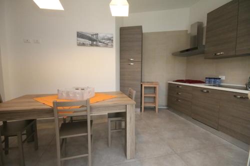 a kitchen with a wooden table with chairs and cabinets at Villa Venera Fontane Bianche Charme Apartments in Fontane Bianche