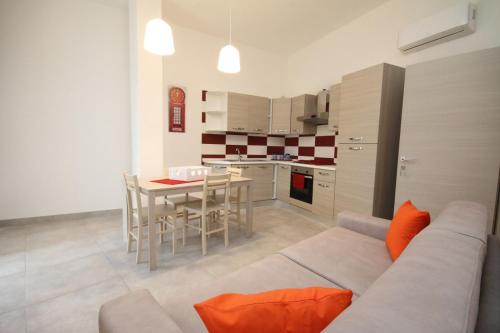a living room with a couch and a table and a kitchen at Villa Venera Fontane Bianche Charme Apartments in Fontane Bianche