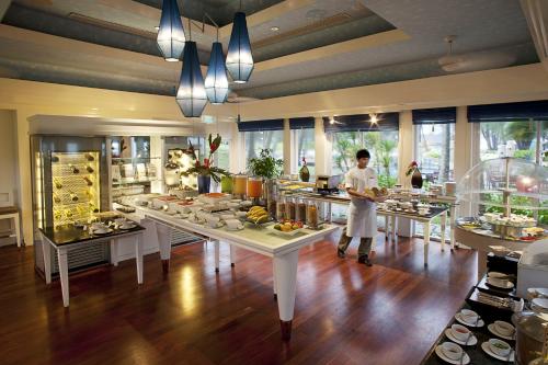 a man in a kitchen with a buffet of food at Dusit Thani Laguna Phuket in Bang Tao Beach