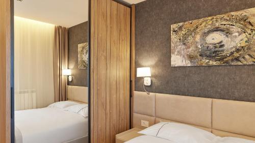 a mirror in a hotel room with two beds at Vip Casa Club Zlatibor in Zlatibor