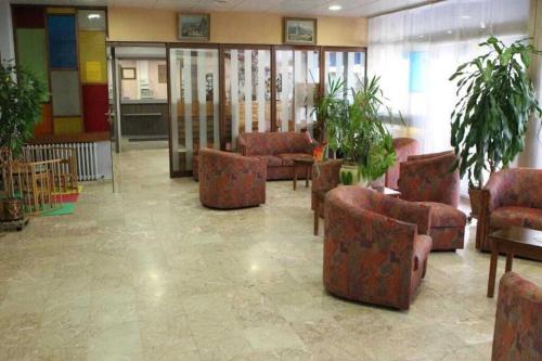 a lobby with couches and plants in a building at Les Portes du Cantal in Massiac