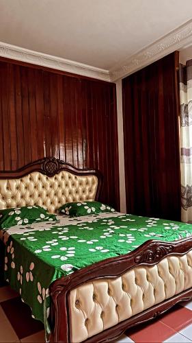 a bedroom with a bed with a green comforter at Kc luxury in Yaoundé
