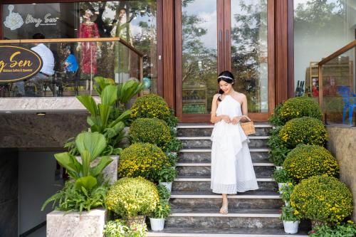 a woman in a white dress standing on the stairs at MK Riverside Apartment by Haviland in Da Nang