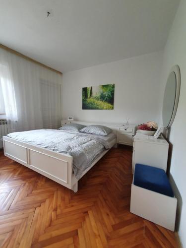 Ferienhaus Brice / Mostar في موستار: غرفة نوم بسرير ابيض ومرآة