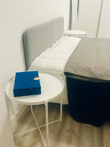 a bed and a table with a blue book on it at Ajuda's Heart in Lisbon