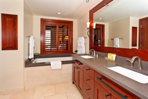 un bagno con due lavandini e un grande specchio di Ko Olina Beach Villas O822 a Kapolei
