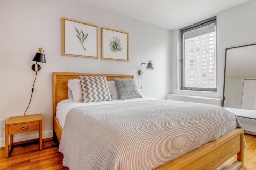 a bedroom with a large bed and a window at Midtown 1br w doorman gym nr Times Square NYC-1208 in New York