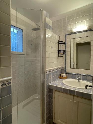 La salle de bains est pourvue d'une douche, d'un lavabo et d'un miroir. dans l'établissement Maison dans le domaine du golf, à Roquebrune-sur Argens