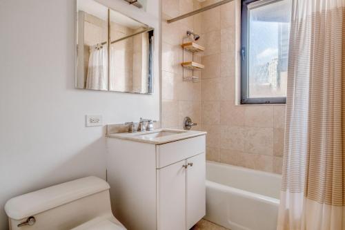 a bathroom with a toilet and a sink and a tub at Midtown 1br w doorman gym nr Times Square NYC-1208 in New York