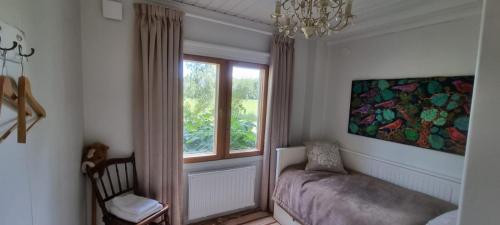 um quarto com uma janela, uma cadeira e um sofá em Villa Söder em Ojakkala