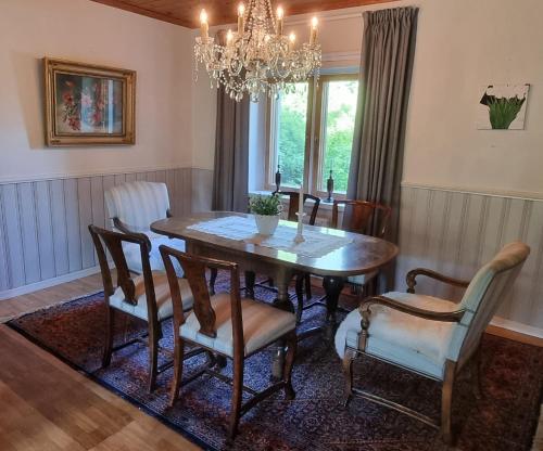 einen Esstisch mit Stühlen und einem Kronleuchter in der Unterkunft Villa Söder in Ojakkala