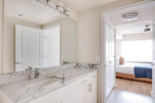 a white bathroom with a sink and a bedroom at North Bethesda 1br w wd pool gym nr metro WDC-608 in North Bethesda