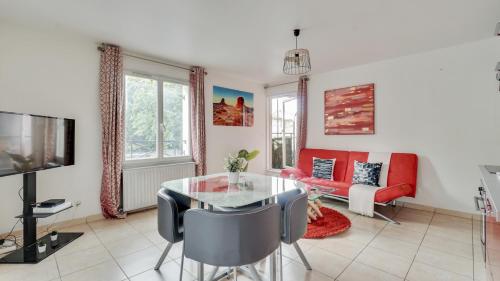 ein Wohnzimmer mit einem Glastisch und einem Sofa in der Unterkunft Chic apart with parking and balcony near Paris in Aubervilliers