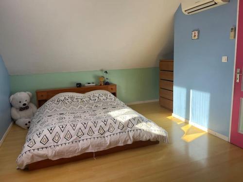 een slaapkamer met een bed en een teddybeer bij Maison familiale avec terrain in Orchamps-Vennes