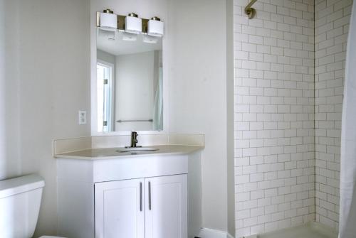 een witte badkamer met een wastafel en een spiegel bij East Cambridge 1br w gym wd near T stop BOS-961 in Boston