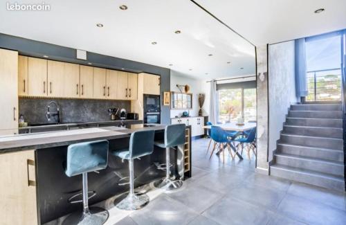 une cuisine et une salle à manger avec un comptoir et des chaises dans l'établissement villa calme 10-12 couchages, à La Roquette-sur-Siagne
