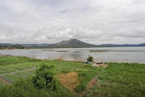 una gran masa de agua con una montaña en el fondo en Baruna Lakeside View en Kubupenlokan