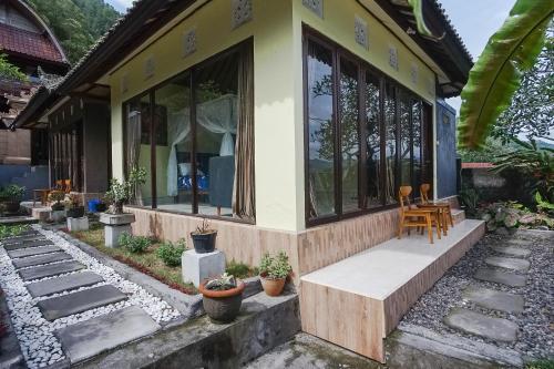 una pequeña casa con porche y algunas plantas en Baruna Lakeside View en Kubupenlokan