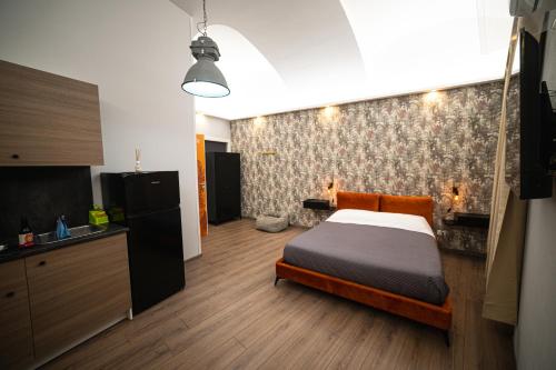 1 dormitorio con 1 cama y cocina. en Regis 2 Appartamenti Resort centro storico en Chivasso