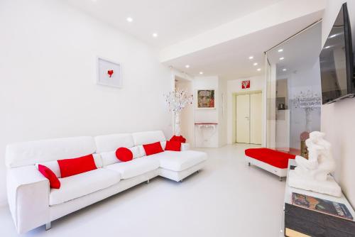 een witte woonkamer met een witte bank en rode kussens bij Morghen Red Passion and Pop Art in Napels