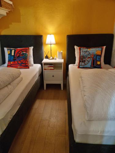 a bedroom with two beds and a table with a lamp at Sophie House foreigners women only in Seoul