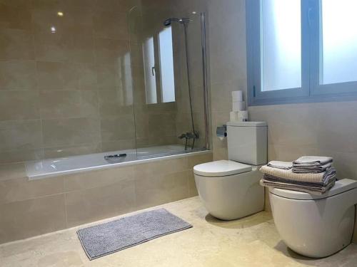a bathroom with a toilet and a shower and a tub at Villa Mar Azul in Santa Ponsa