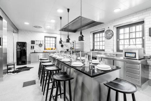a large kitchen with a bar with stools in it at Hotel Riesengebirge in Neuhof an der Zenn