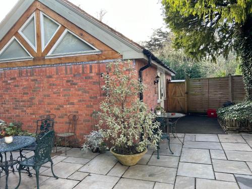 a patio with tables and chairs and a building at The Potting Shed in Warwick
