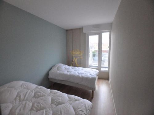 a bedroom with two beds and a window at Victory25 in Le Touquet-Paris-Plage