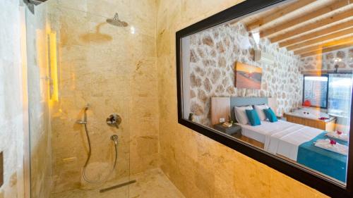 a bathroom with a shower and a bed in a room at Villa Nazlısu in Kaş