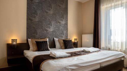 a large bed in a room with a large window at Family Apartman in Eplény