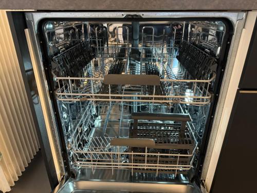 a dishwasher with many dishes inside of it at See und Berge Garden in Faulensee