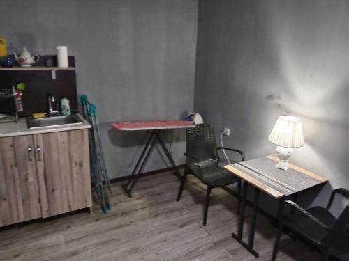 a kitchen with a table and chairs and a table with a lamp at A cozy bedsit! in Tashkent