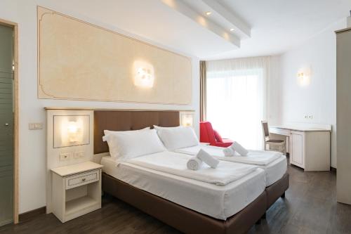 a bedroom with a large bed with a large painting on the wall at Hotel Sogno del Benaco in Limone sul Garda
