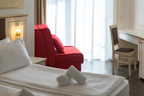 a hotel room with a bed and a red chair at Hotel Sogno del Benaco in Limone sul Garda