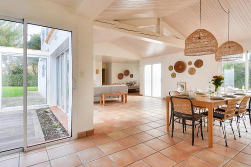 une salle à manger avec une table et des chaises dans l'établissement Maison pour 14 - 150 m de la plage de la Clère, à Noirmoutier-en-l'lle