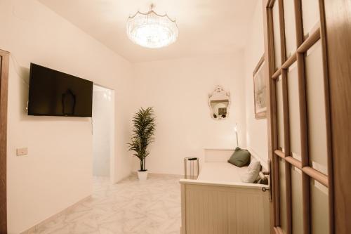 uma sala de estar branca com uma televisão e um sofá em Renaissance Apartment em Roma