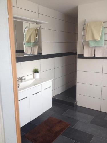 een badkamer met een wastafel, een spiegel en handdoeken bij Pension Hedy in Bad Schallerbach