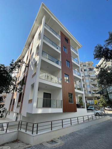 a tall apartment building with a red door at Cozy 2-Bedroom Apartment, Cleopatra Beach, Alanya in Alanya