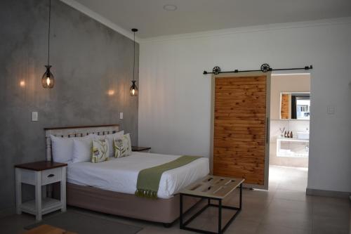 Symponia Guesthouse في Ghanzi: غرفة نوم بسرير وجدار خشبي
