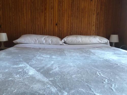 a large bed with two pillows on top of it at L'abri de Pila in Gressan