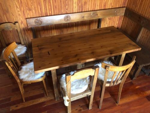 a wooden table and two chairs and a wooden table and chairs at L'abri de Pila in Gressan