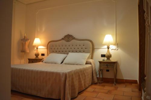 a bedroom with a bed with two pillows and two lamps at Hospedería Bodas de Camacho in Munera